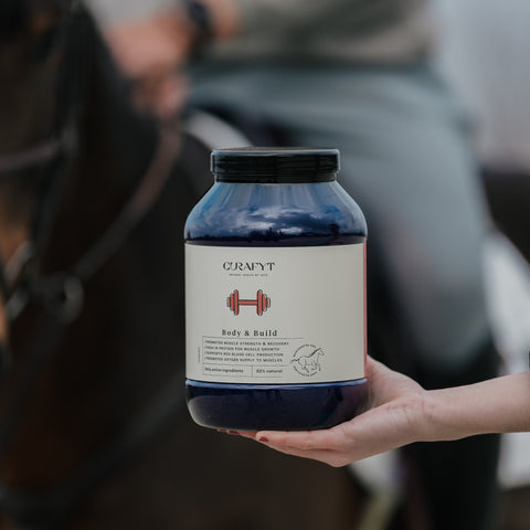 Person holding a jar labeled 'Body&Build Curafyt" with a blurred background